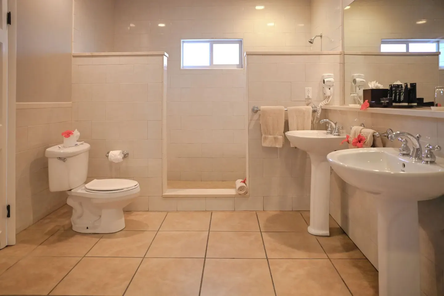Spacious guest bathroom with shower and pedestal sinks at St. James's Club Antigua.