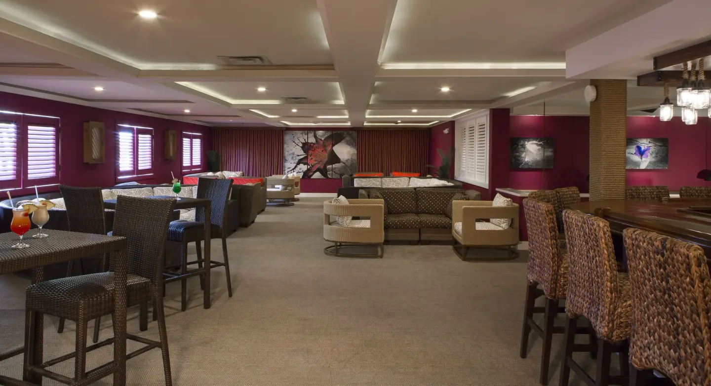 Lounge seating and bar area with magenta walls at St. James's Club Antigua.