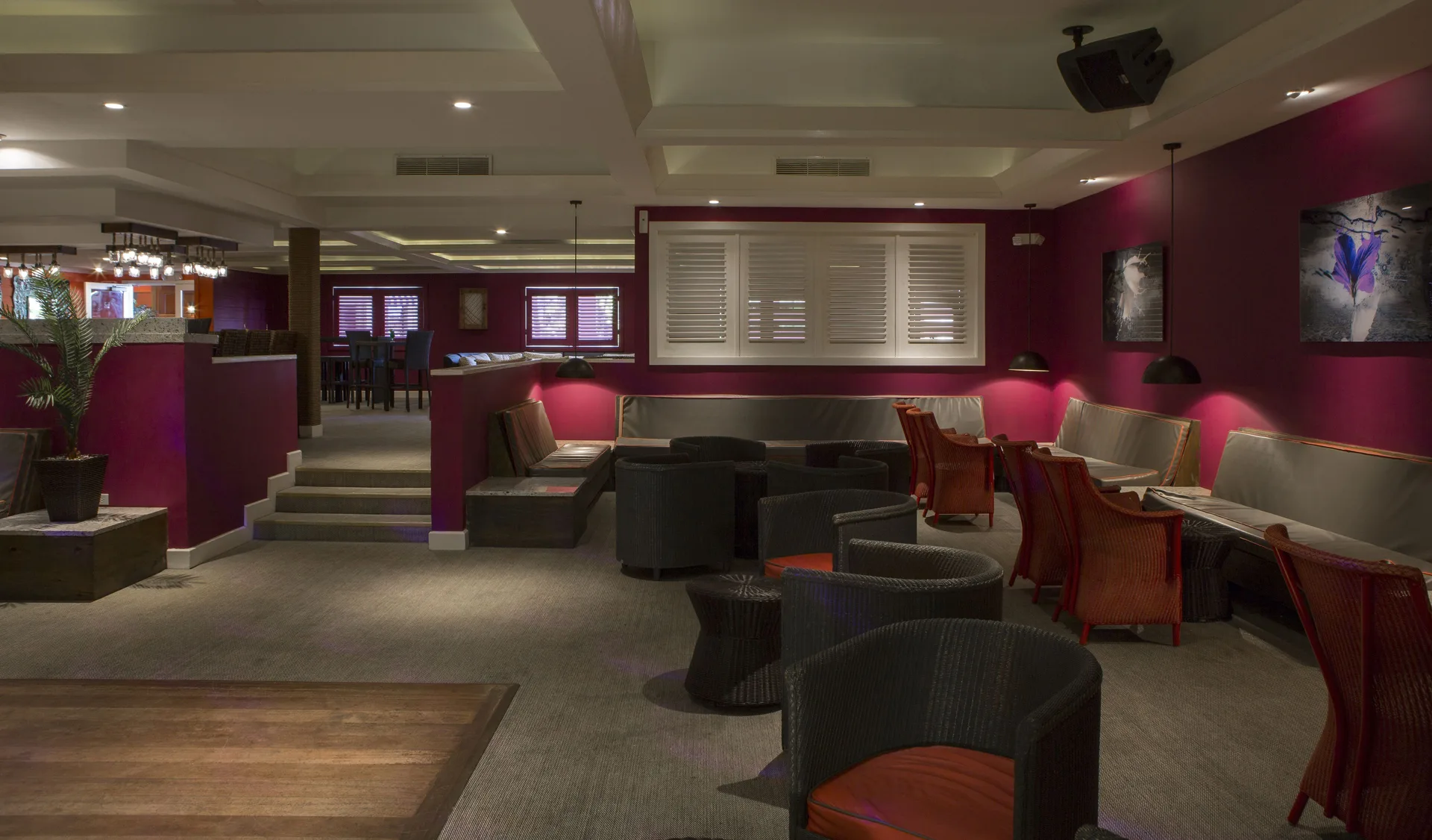 Indoor lounge with armchairs, benches, and bar seating at St. James's Club Antigua.