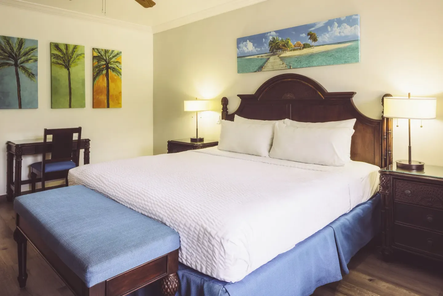 Club Room king bed with blue bench and tropical wall art at St. James's Club Antigua.