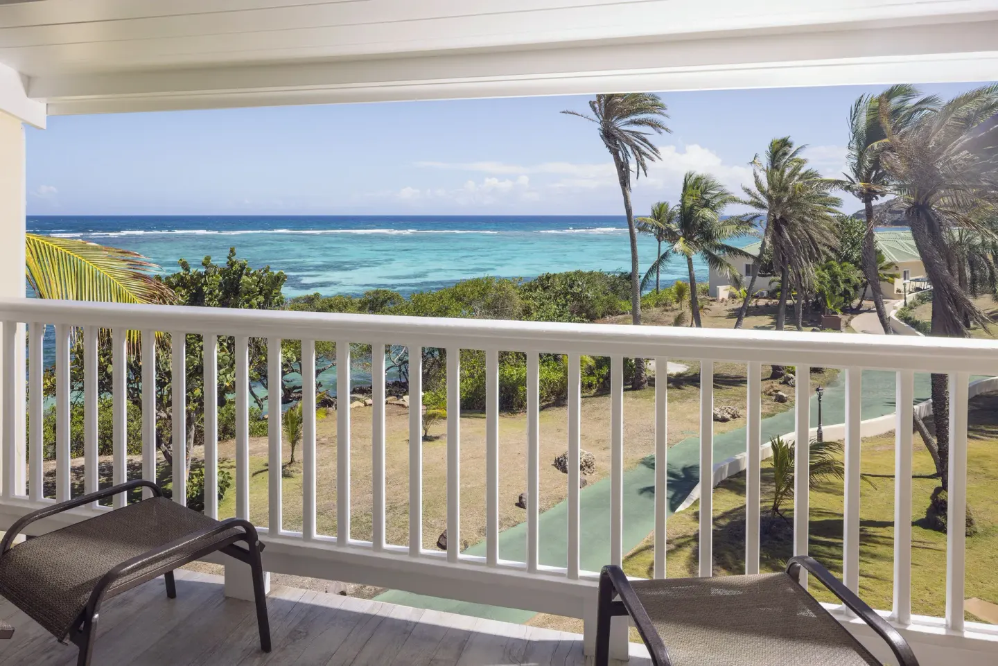 Premium Room balcony with chairs and turquoise ocean view at St. James's Club Antigua.
