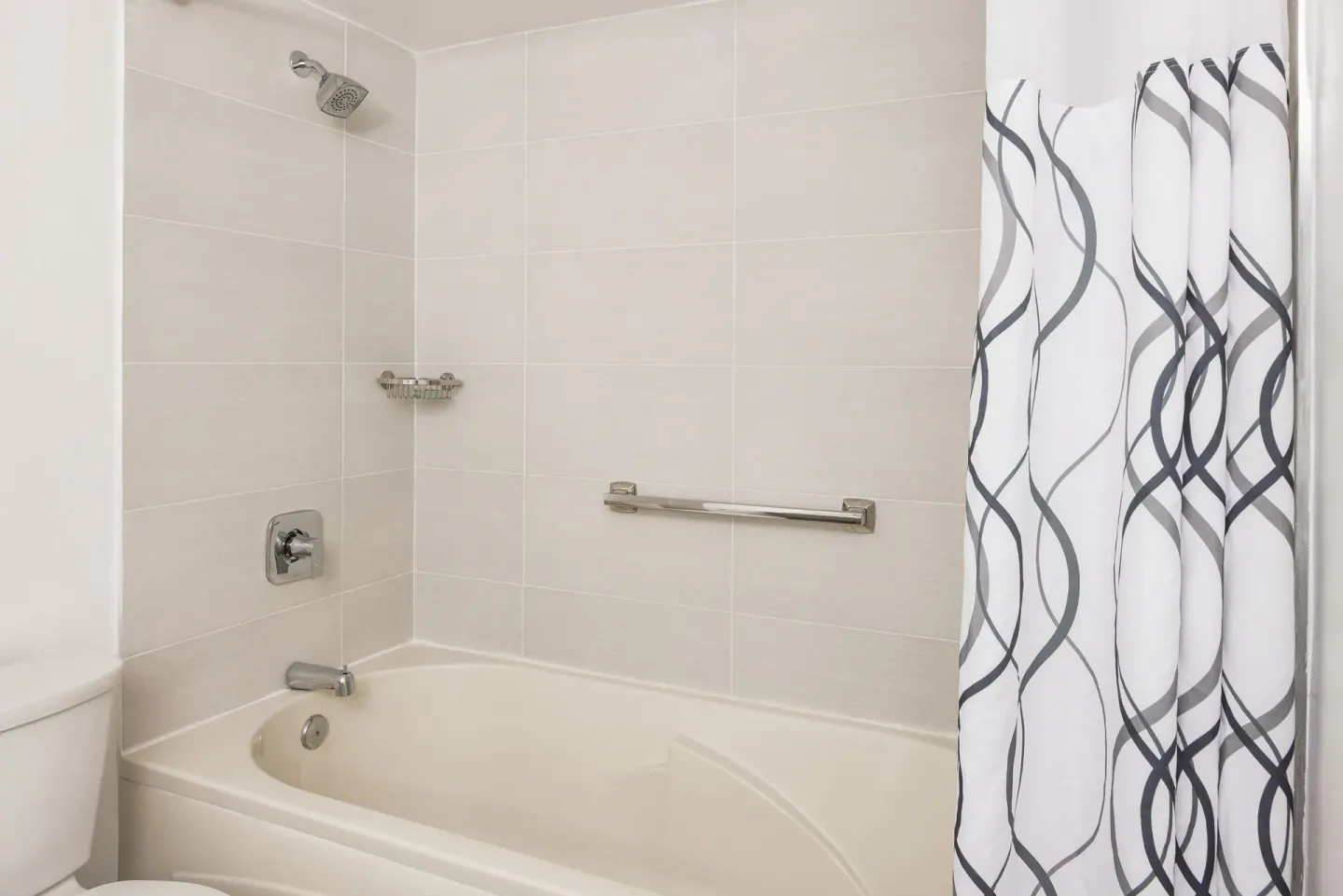 Premium Room bathroom with tub shower and patterned curtain at St. James's Club Antigua.