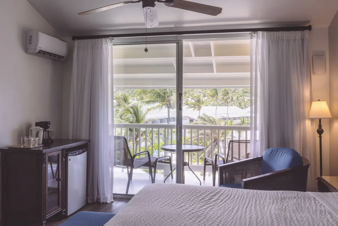 Premium Room with king bed, balcony seating, and palm view at St. James's Club Antigua.