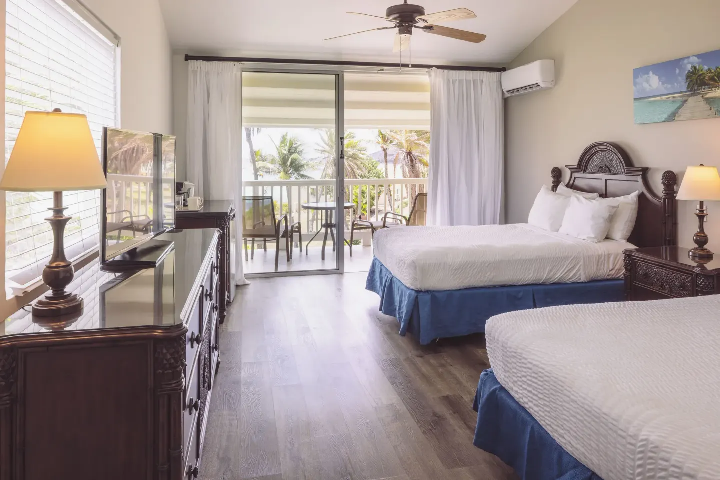 Premium Room with two beds, balcony doors, and tropical view at St. James's Club Antigua.