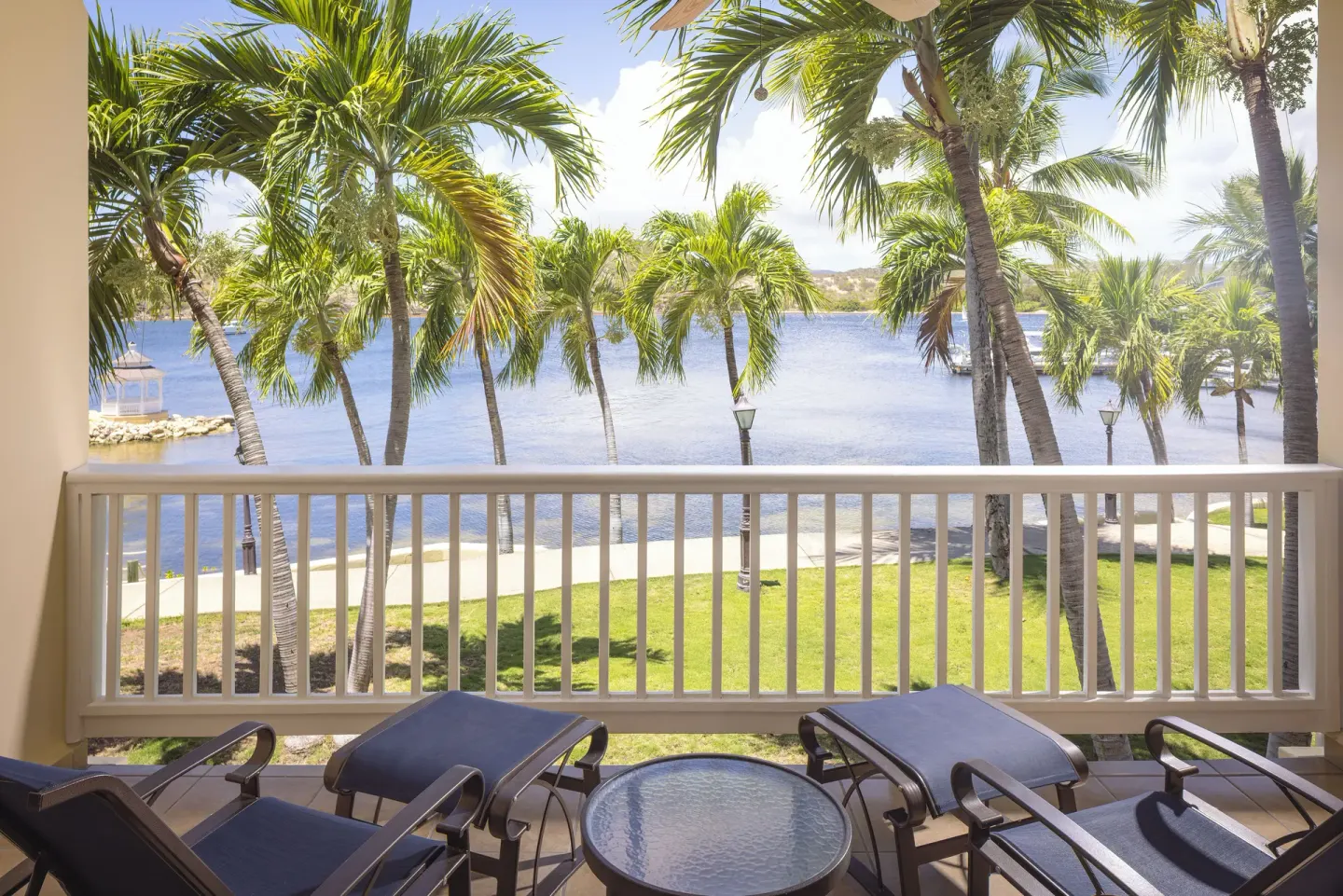 Royal Suite balcony with chairs overlooking palms and water at St. James's Club Antigua.