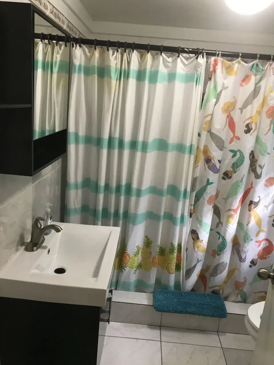 Bathroom with white vanity and patterned shower curtains at St John Inn.
