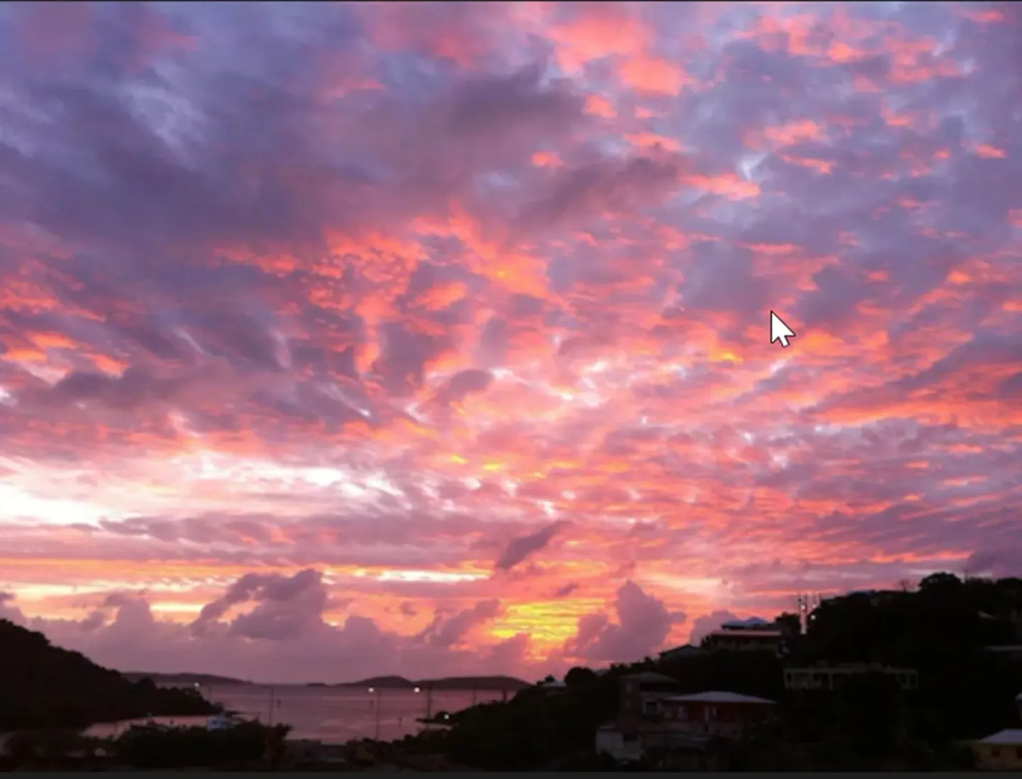 Colorful sunset sky over the harbor and hills near St John Inn.