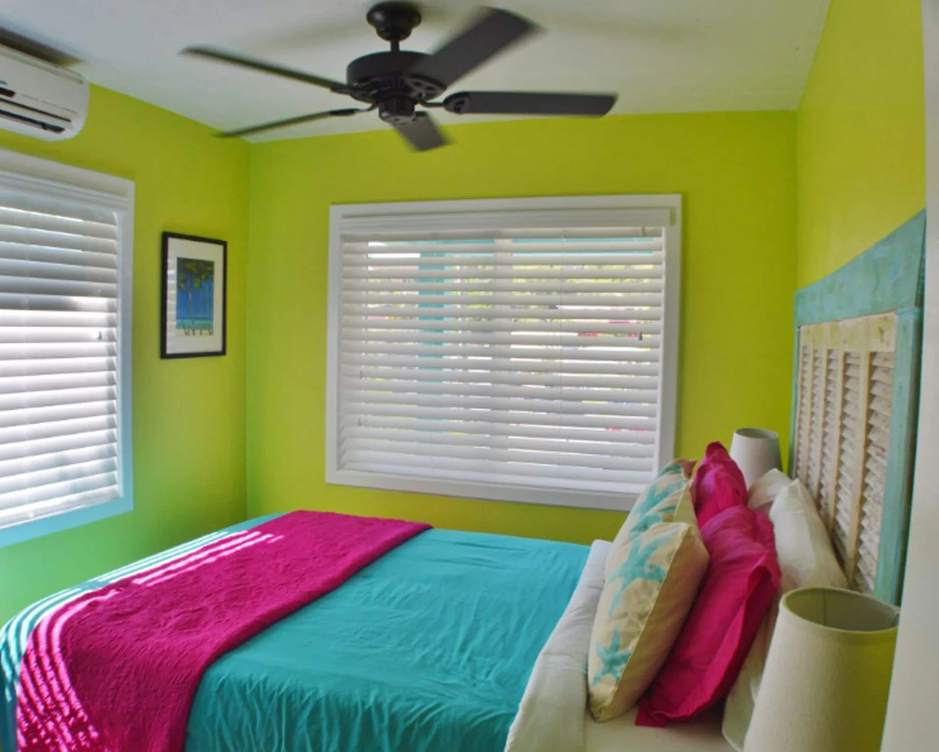 Bright lime guest room with turquoise bedding and white blinds at St John Inn.