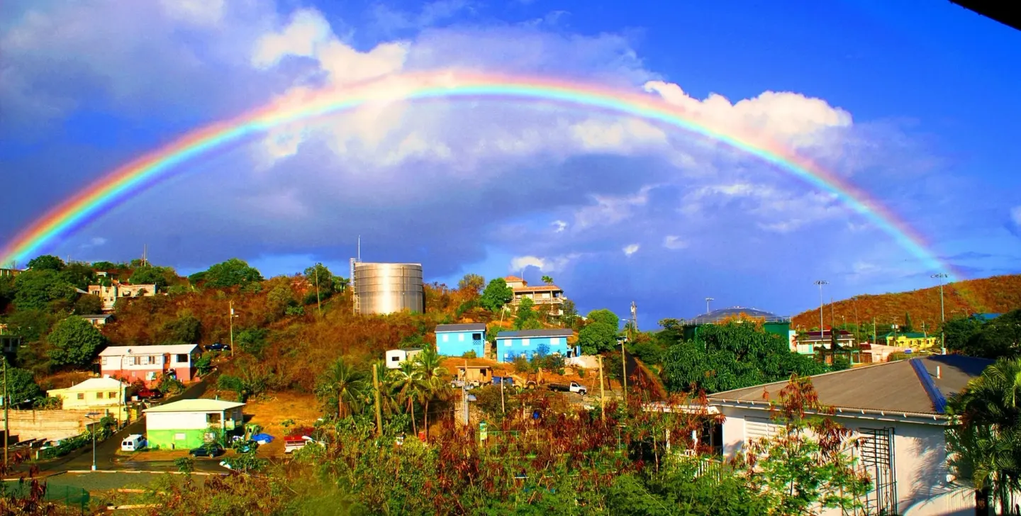 Rainbow over hillside buildings near St John Inn.