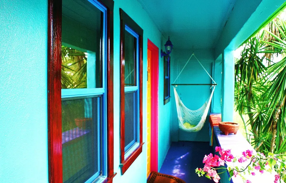 Colorful Standard Room porch with hammock chair and plants at St John Inn.
