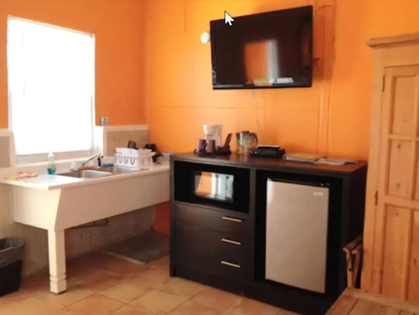 Standard Room kitchenette area with TV, sink, microwave, and mini fridge at St John Inn.
