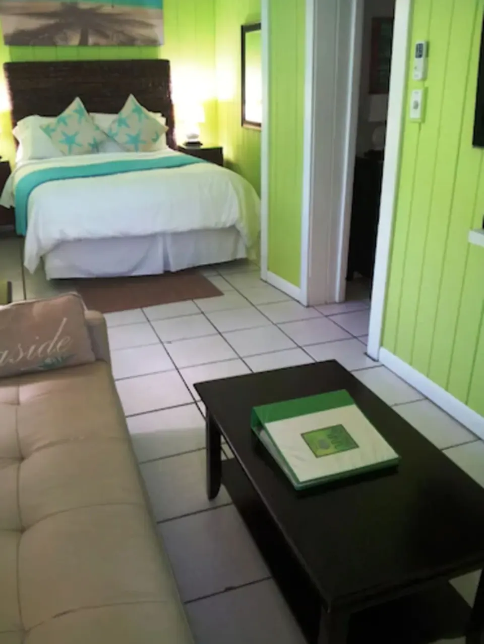 Superior Suite queen bed, sofa, coffee table, and bathroom doorway at St John Inn.