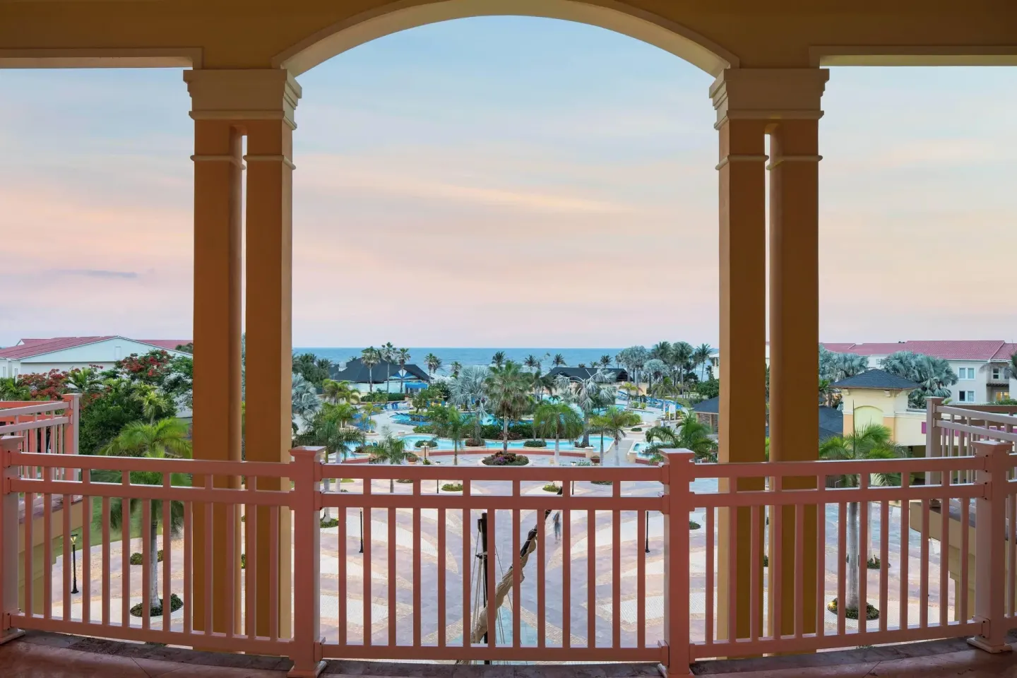 Arched balcony view of the pool, palms and ocean at St Kitts Marriott Beach Resort, Casino & Spa.
