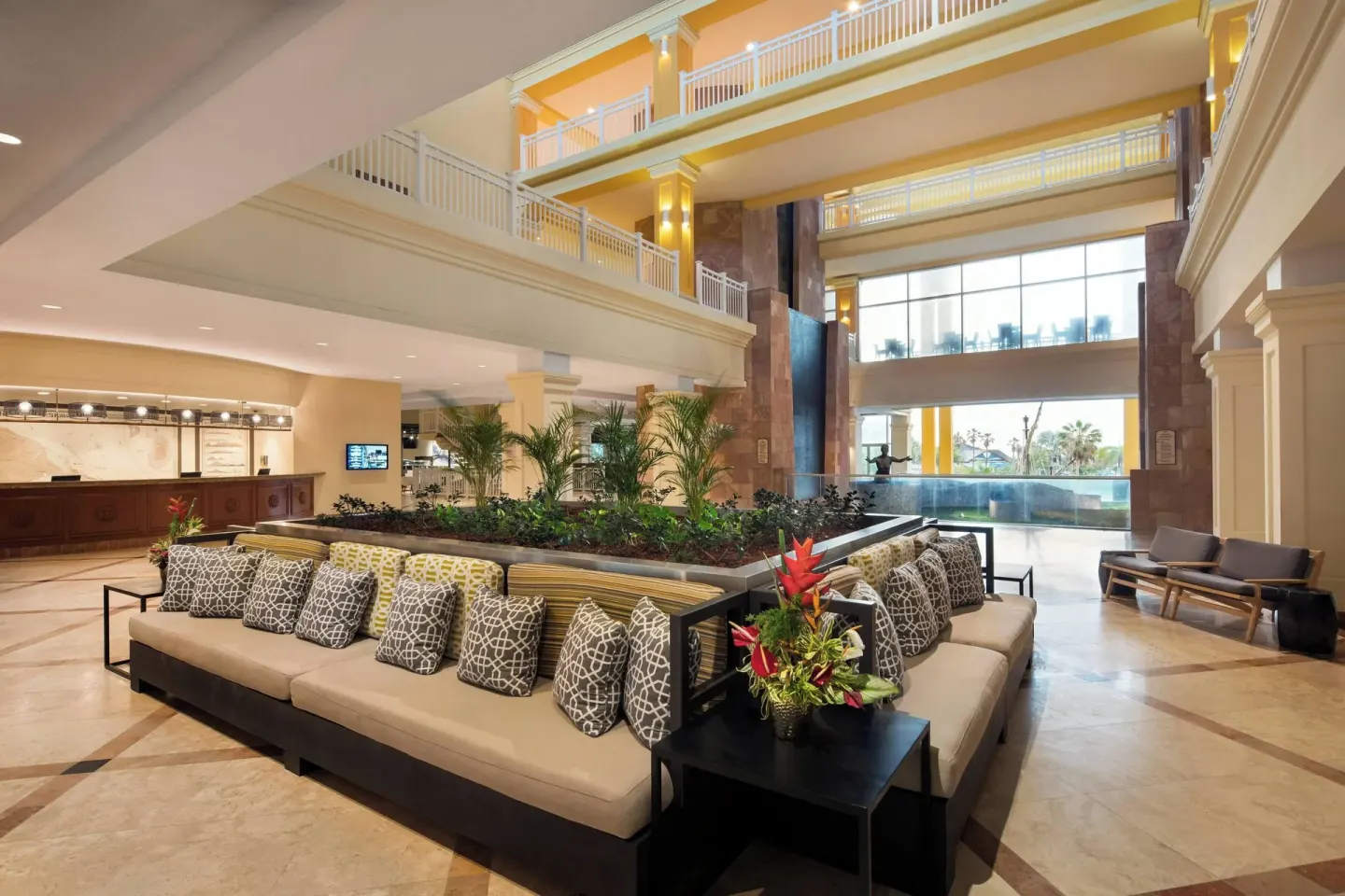 Resort lobby with sofas, tropical plants, and balconies at St Kitts Marriott Beach Resort, Casino & Spa.