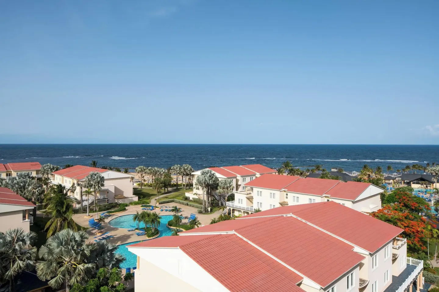 Resort rooftops, pool area, palms, and ocean at St Kitts Marriott Beach Resort, Casino & Spa.