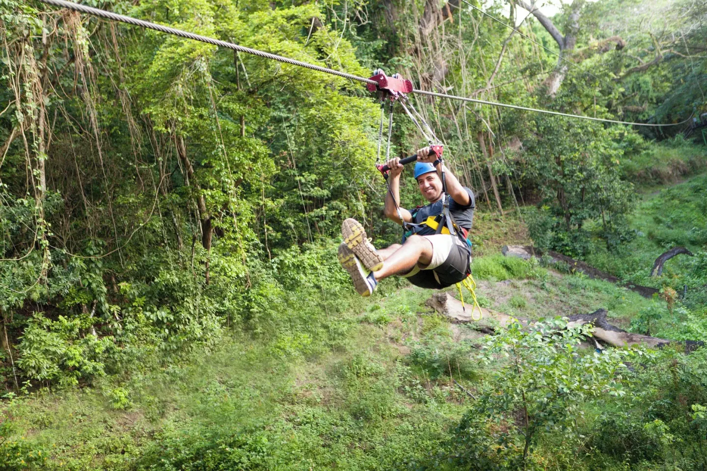 Zipline rider over tropical greenery near St Kitts Marriott Beach Resort, Casino & Spa.