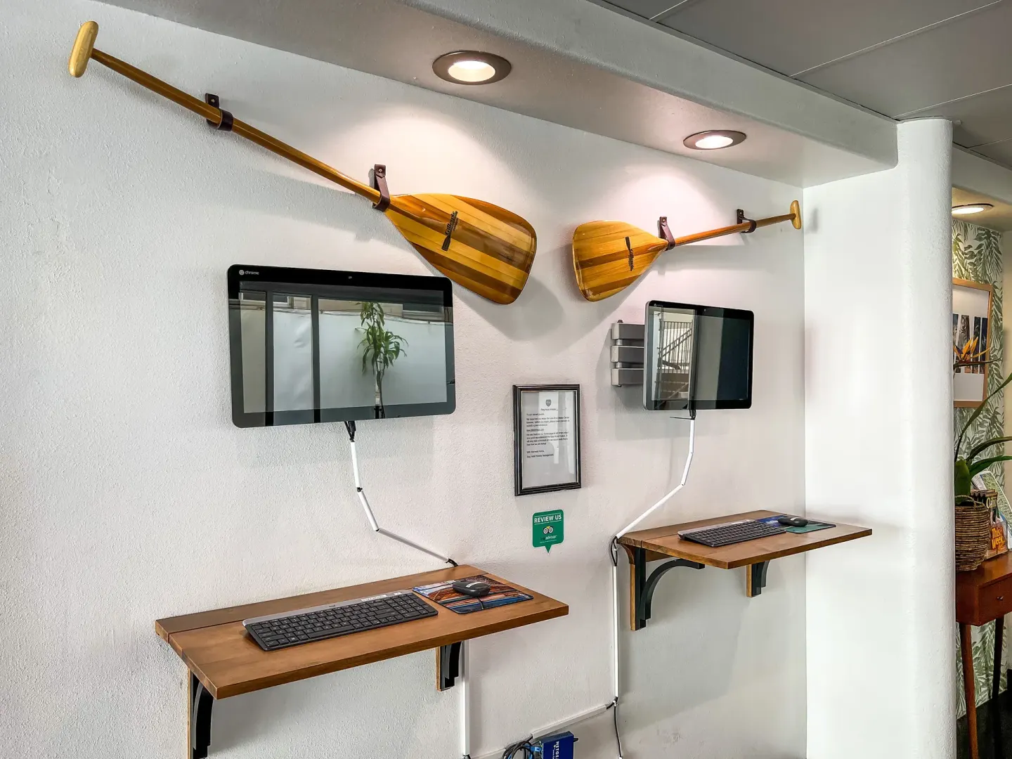 Wall-mounted computers sit below decorative paddles at Stay Hotel Waikiki.