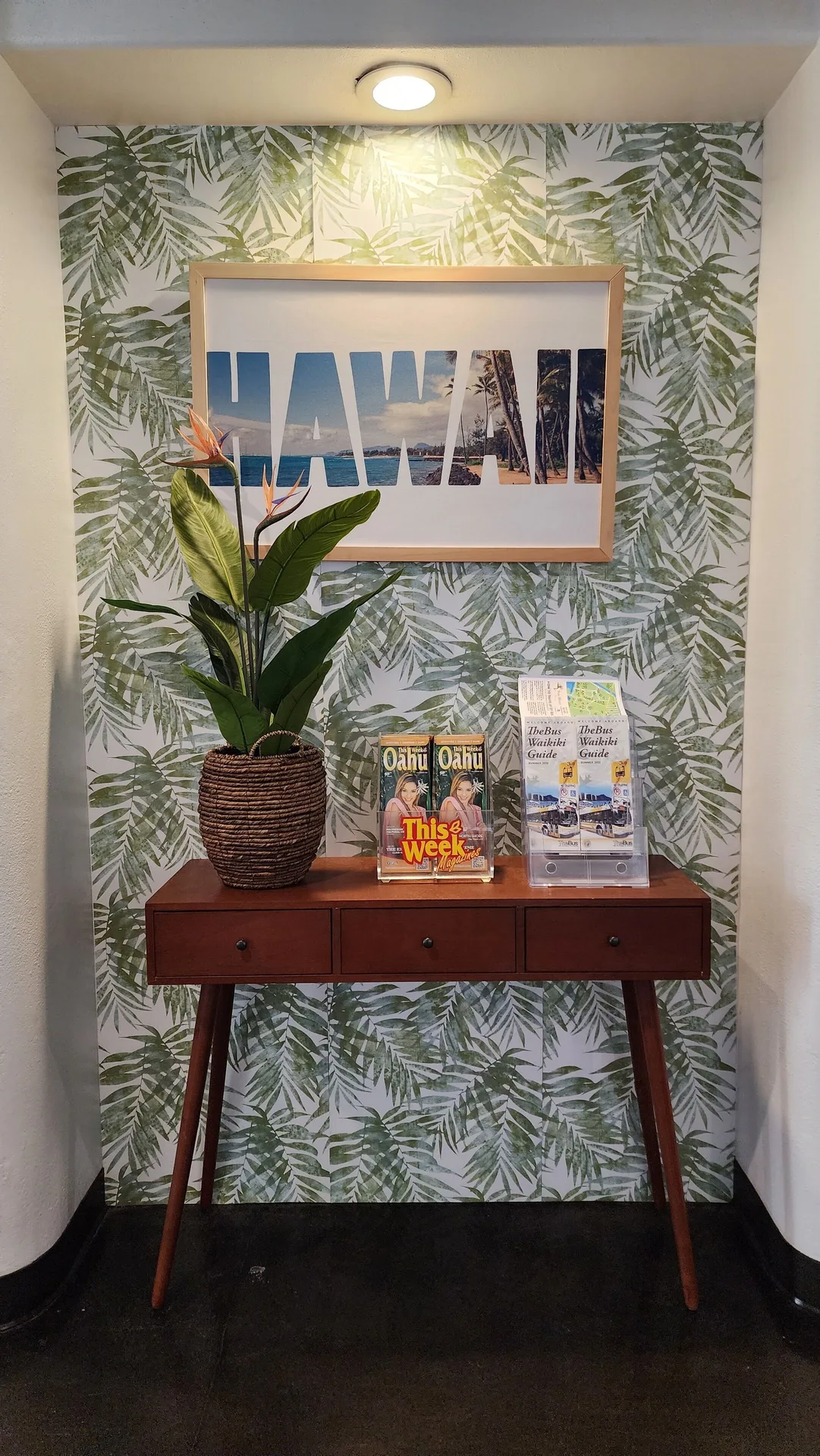 Console table with Hawaii wall art and brochures at Stay Hotel Waikiki.