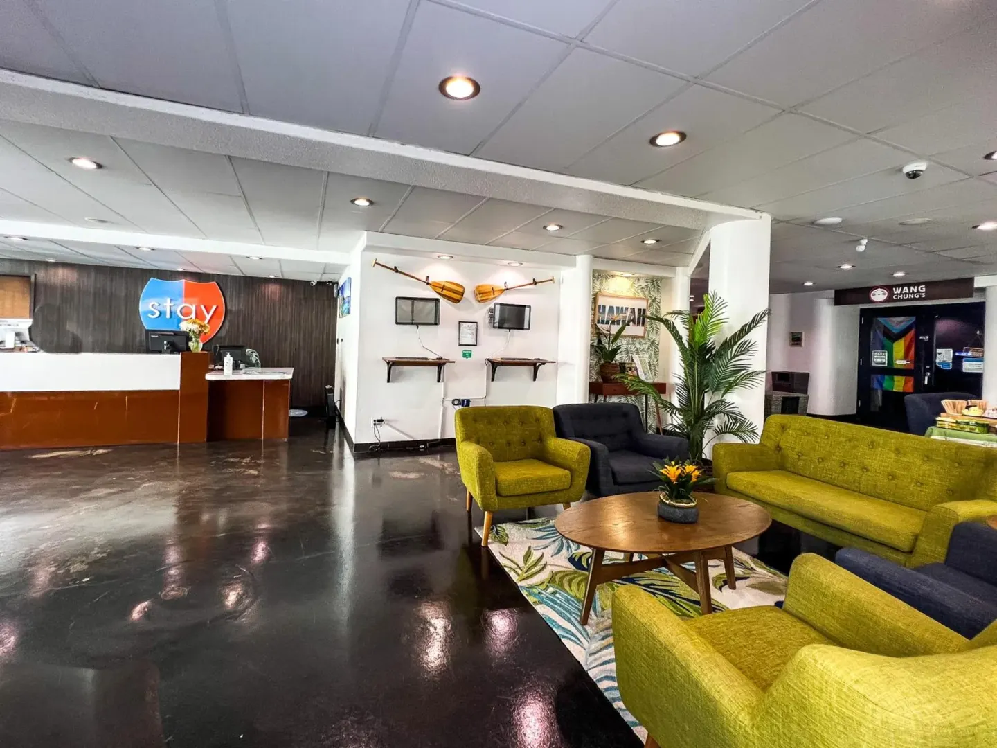 Stay Hotel Waikiki lobby with front desk, colorful seating, and Wang Chung's entrance visible.