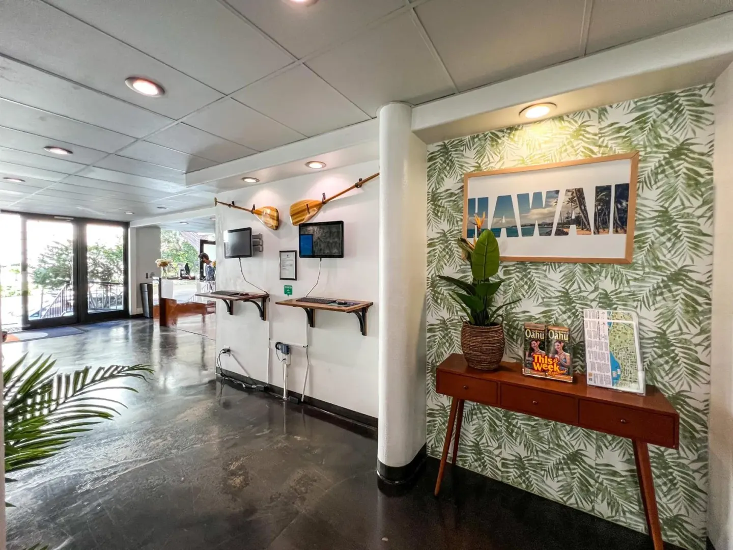 Lobby area with Hawaii wall art and guest computers at Stay Hotel Waikiki.