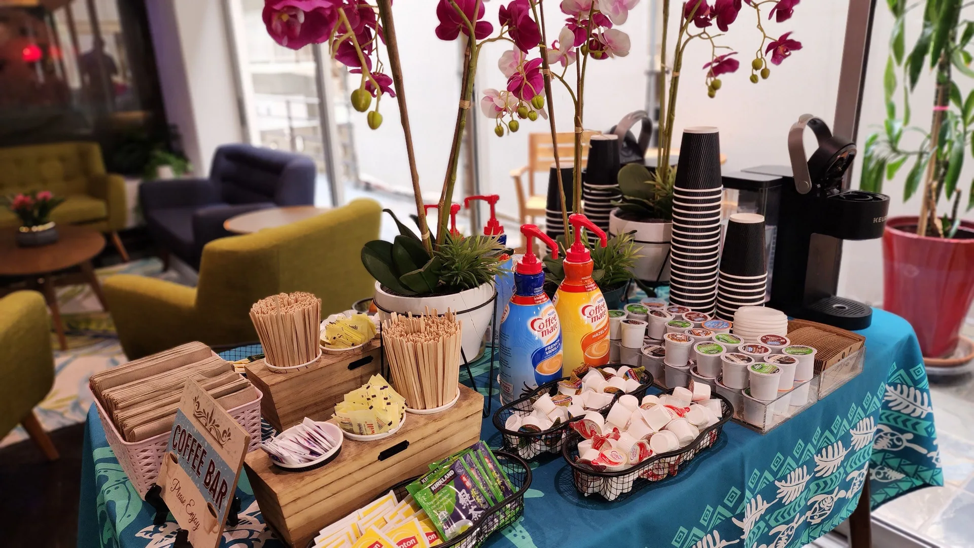 A coffee station with cups, pods, and condiments is set up at Stay Hotel Waikiki.