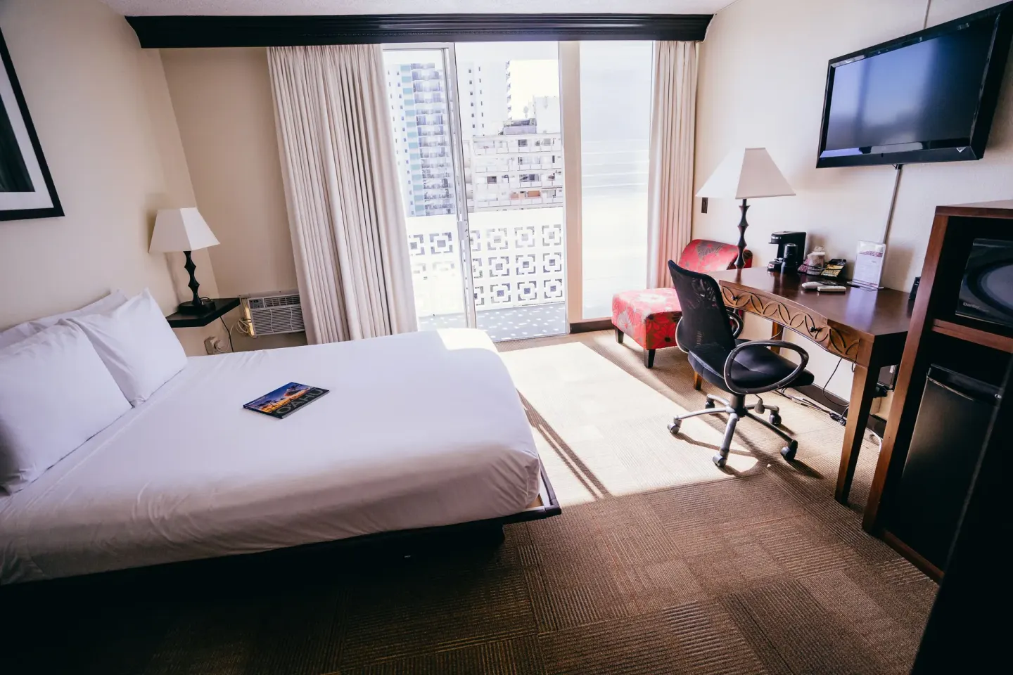 Boutique Room queen bed, desk and balcony doors at Stay Hotel Waikiki.