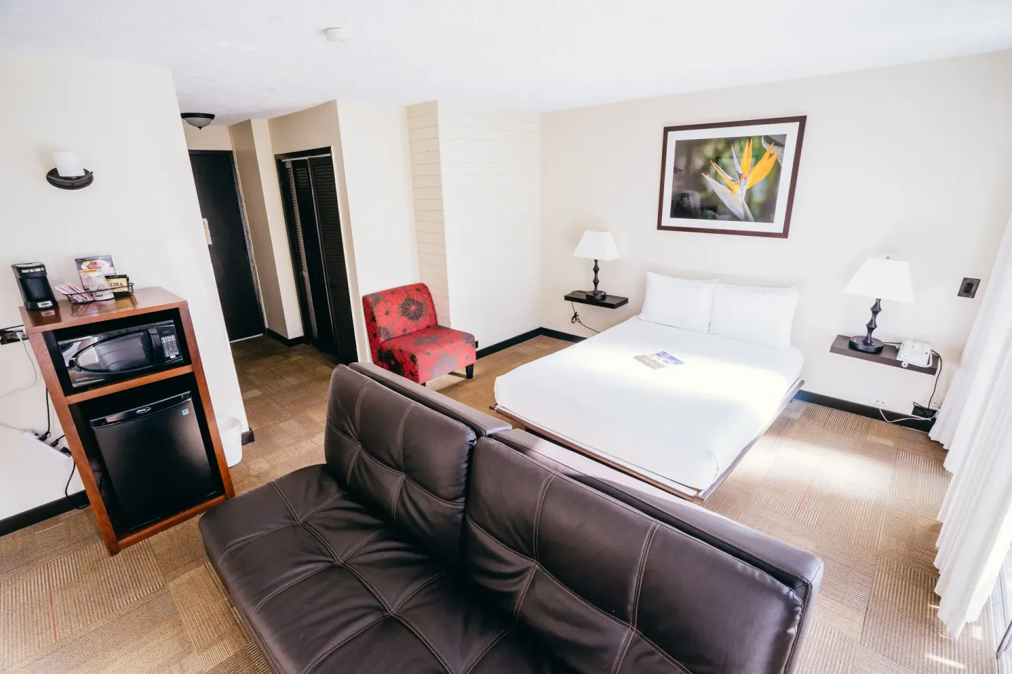Deluxe Room with sofa bed, king bed, lamps and refreshment cabinet at Stay Hotel Waikiki.