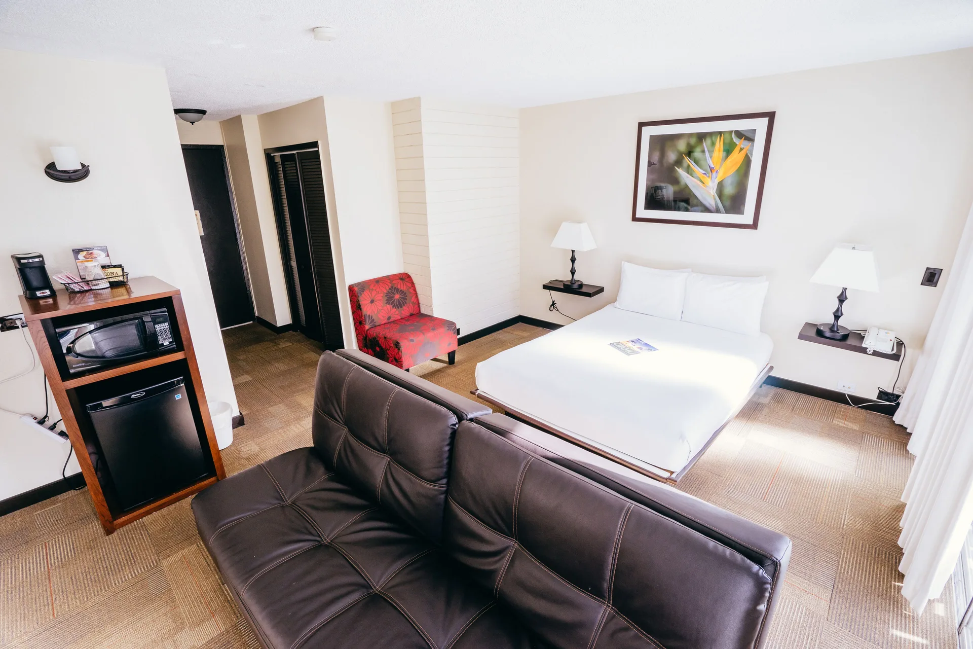 Deluxe Room with sofa bed, king bed, lamps and refreshment cabinet at Stay Hotel Waikiki.