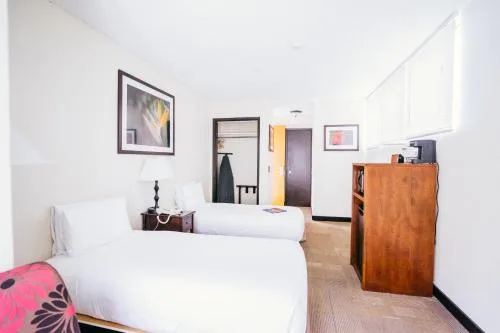 Room with two white beds and wood storage at Stay Hotel Waikiki.