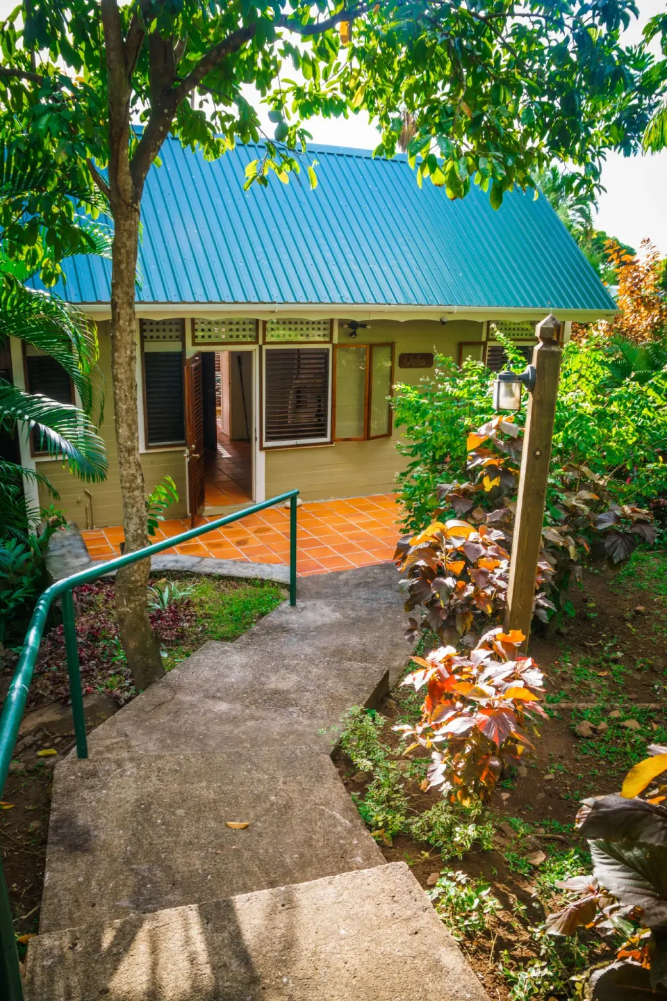 Garden path and steps leading to a villa with a blue roof at Stonefield Villa Resort.