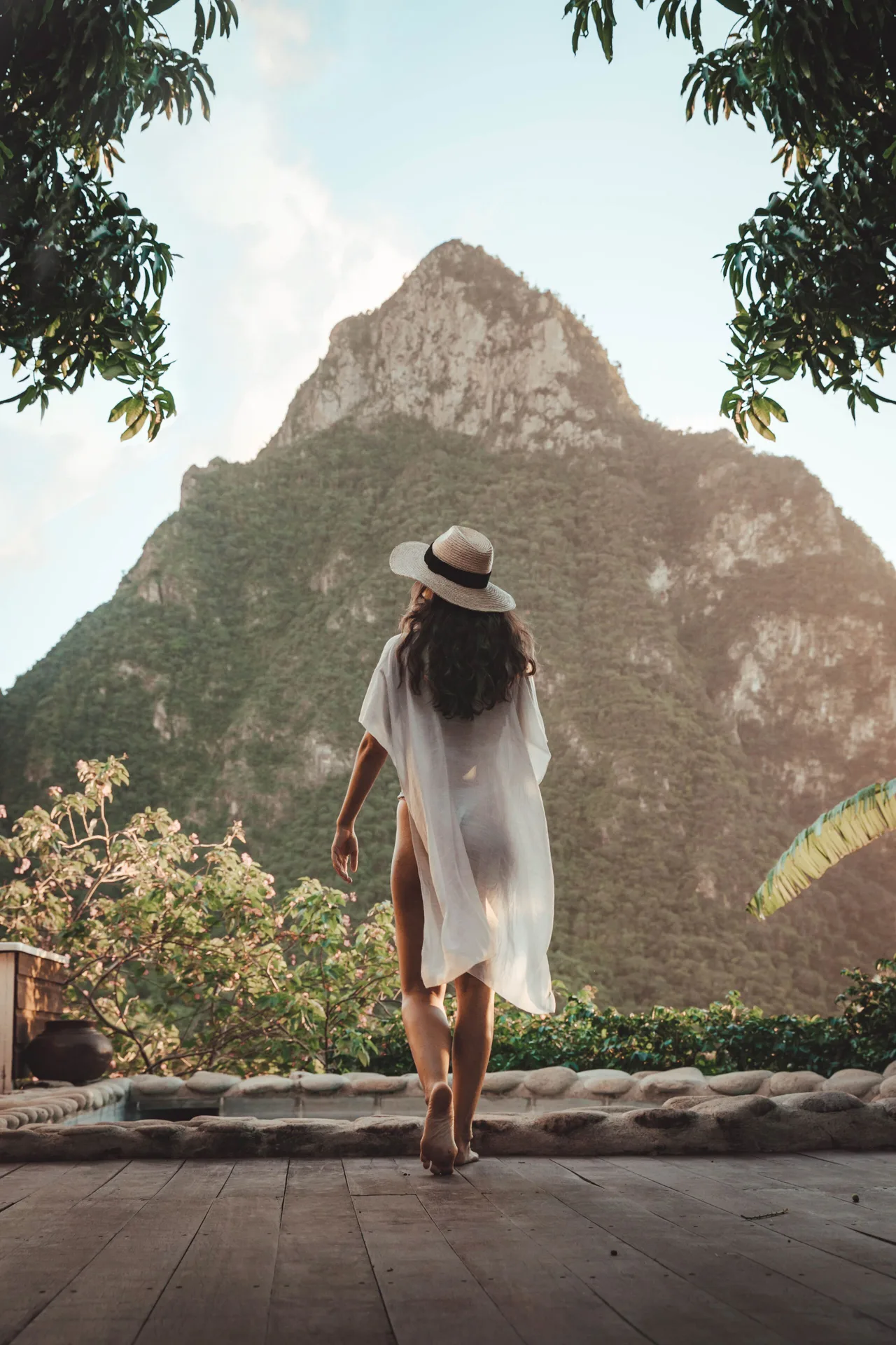 Guest in a sunhat walking toward a mountain view at Stonefield Villa Resort.