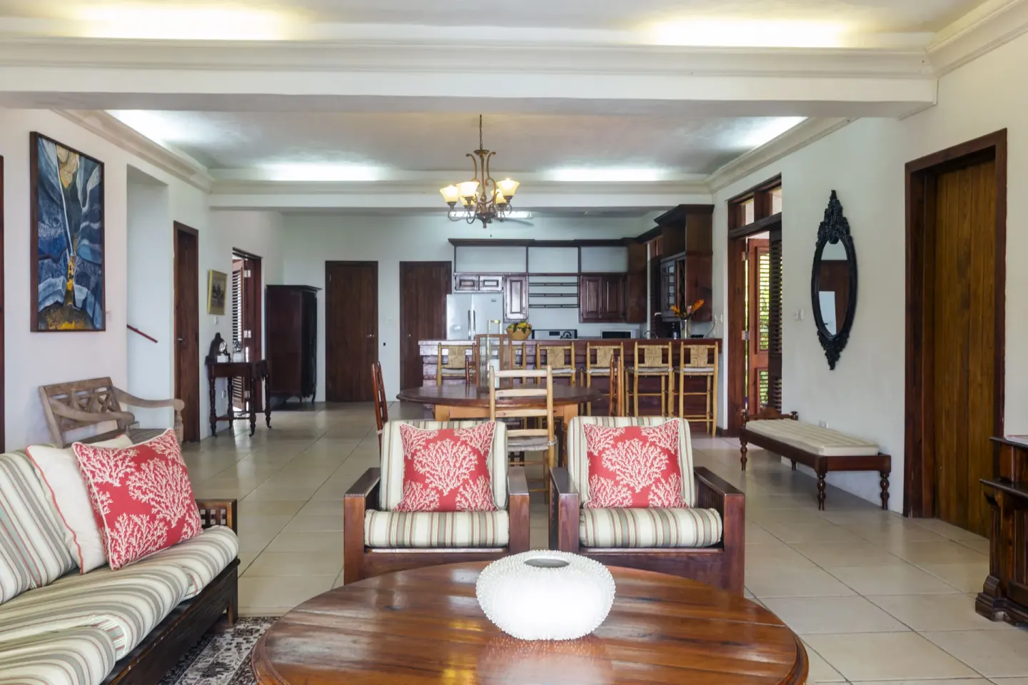 Open-plan villa lounge and kitchen with dining chairs at Stonefield Villa Resort.