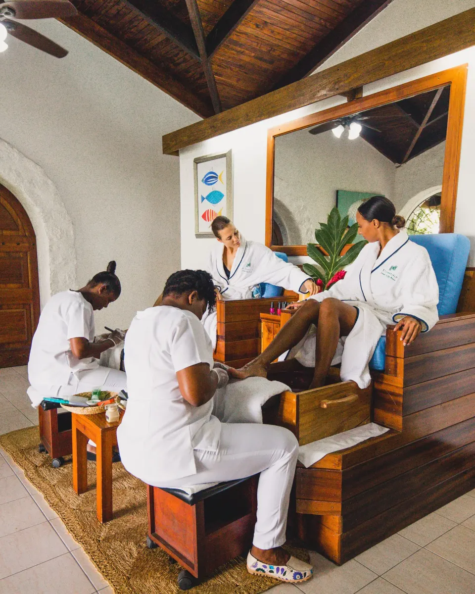 Guests receiving pedicures in a spa room with wood chairs at Stonefield Villa Resort.