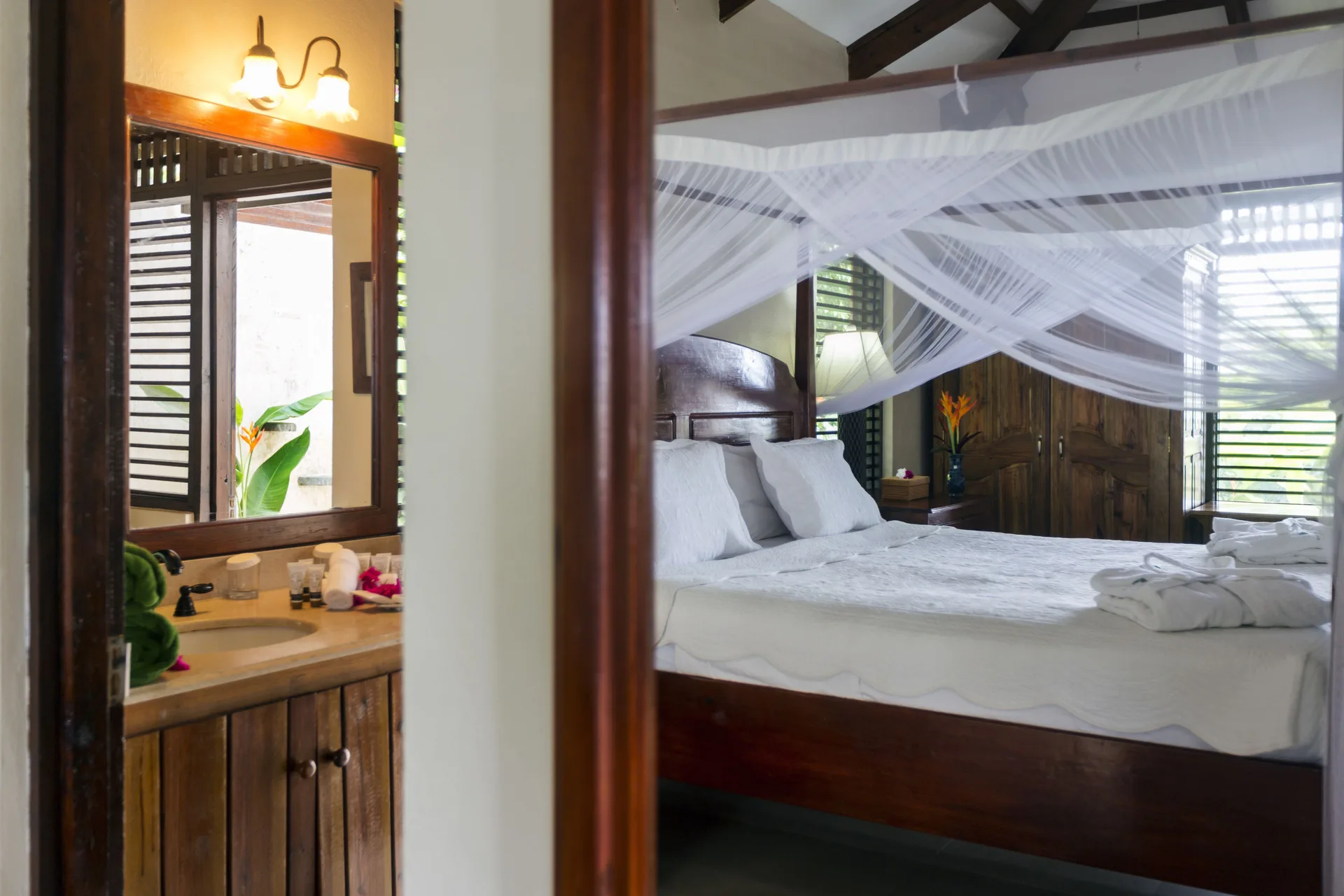 Canopy bed and vanity area inside a villa bedroom at Stonefield Villa Resort.