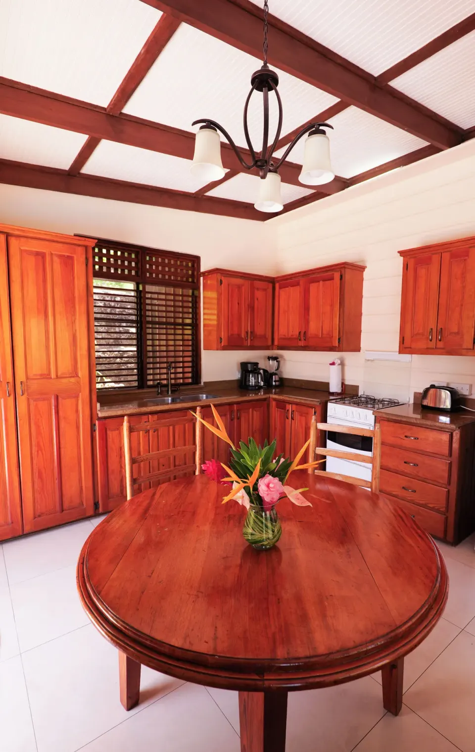 Kitchen and round dining table with tropical flowers at Stonefield Villa Resort.