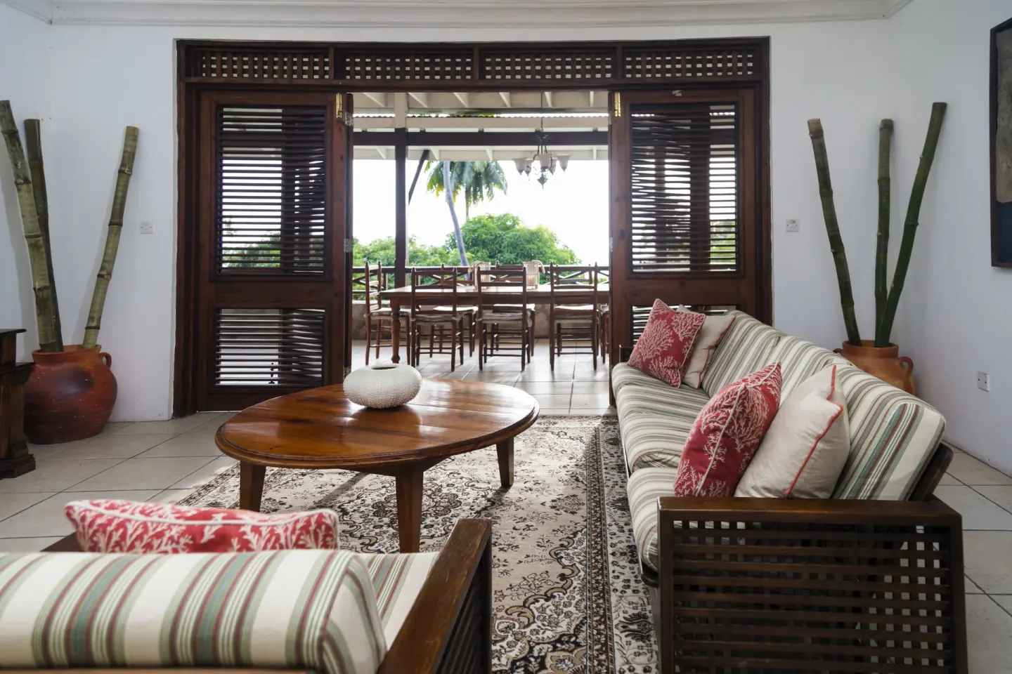Villa living room with striped sofas opening to a terrace at Stonefield Villa Resort.