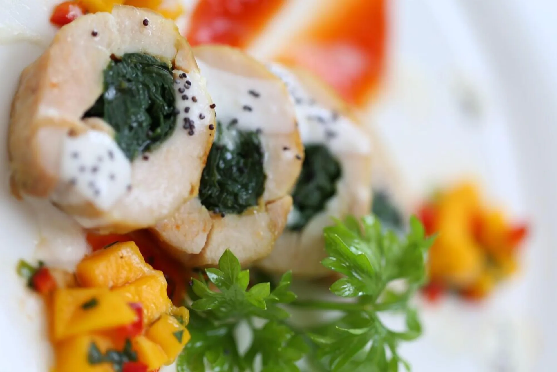 A plated entrée with stuffed chicken, greens, and diced vegetables at Stonefield Villa Resort.