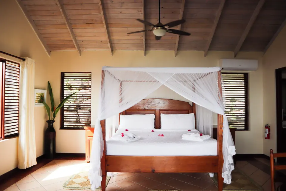 Ocean View Villa king bed with mosquito netting at Stonefield Villa Resort.