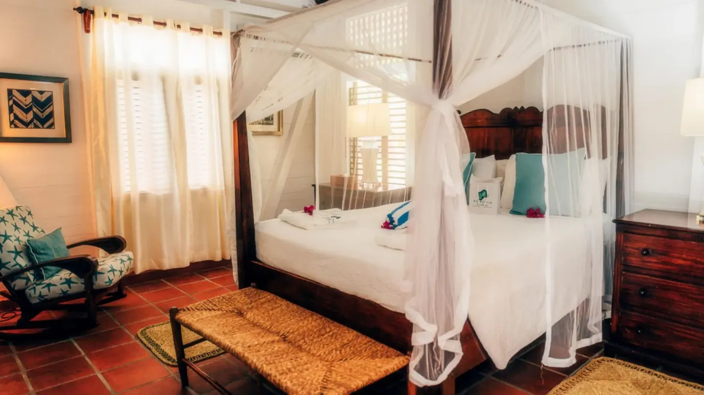 Villa with Garden View bedroom with canopy bed and seating at Stonefield Villa Resort.