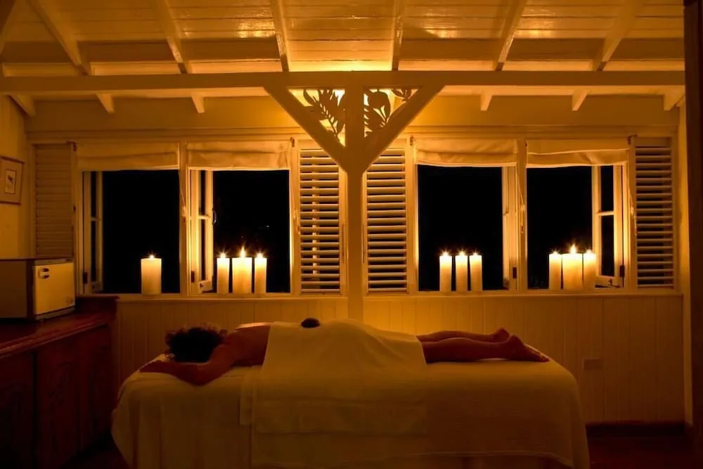 A candlelit spa treatment room with a massage table at Strawberry Hill.