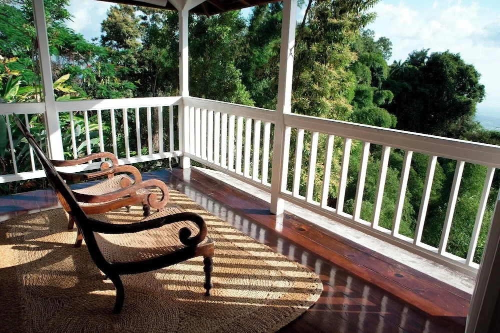 Covered veranda with lounge chairs overlooking trees at Strawberry Hill.