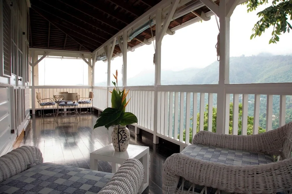 Covered veranda with wicker seating and mountain views at Strawberry Hill.
