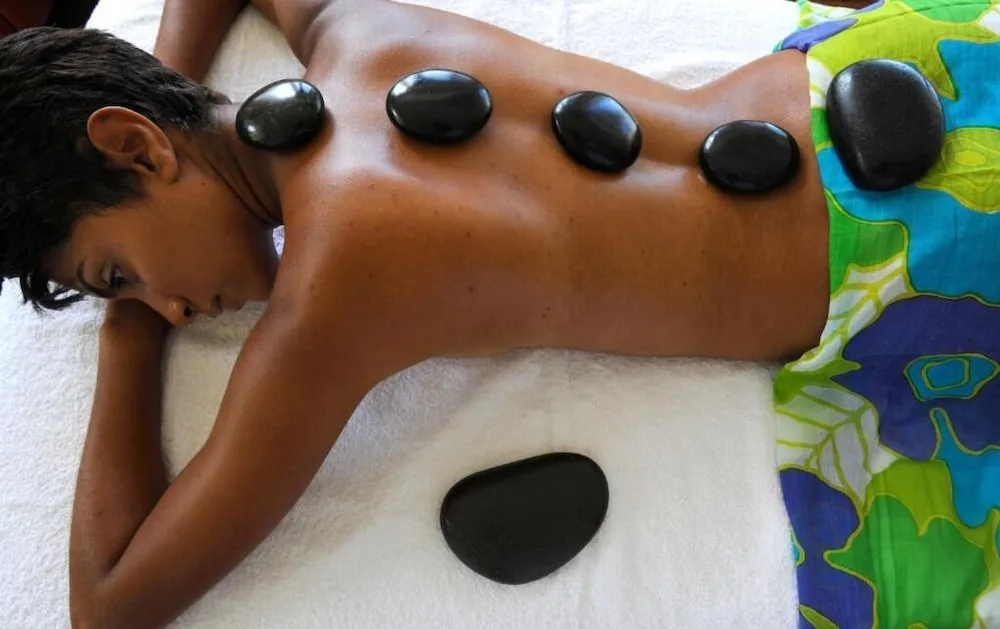 Hot stone massage treatment on a guest's back at Strawberry Hill.