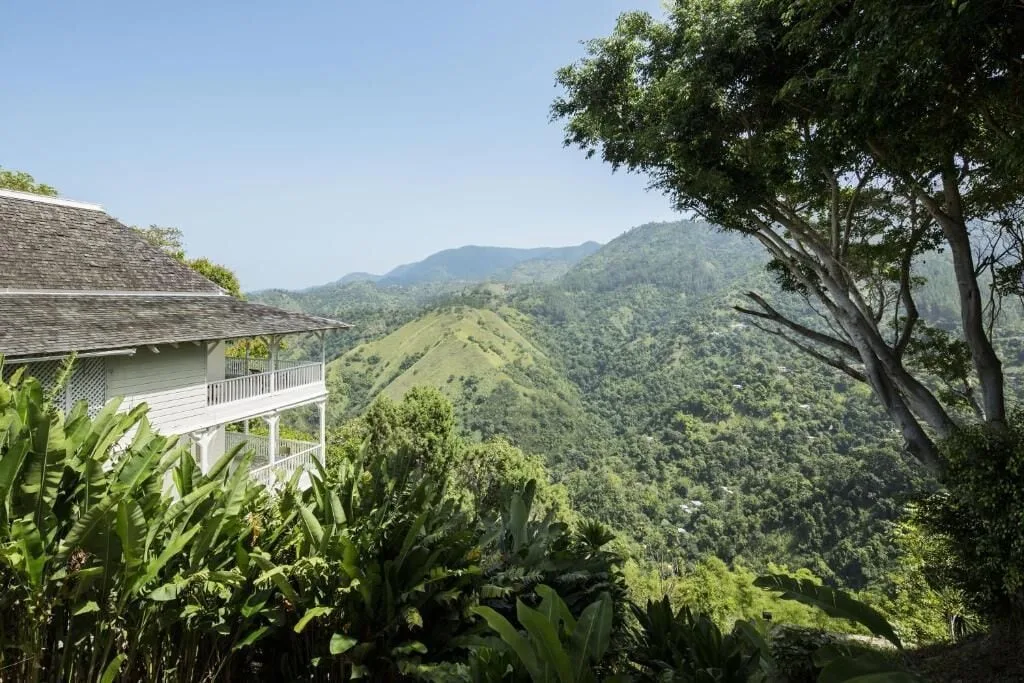 A hillside building overlooks green mountain valleys and trees at Strawberry Hill.