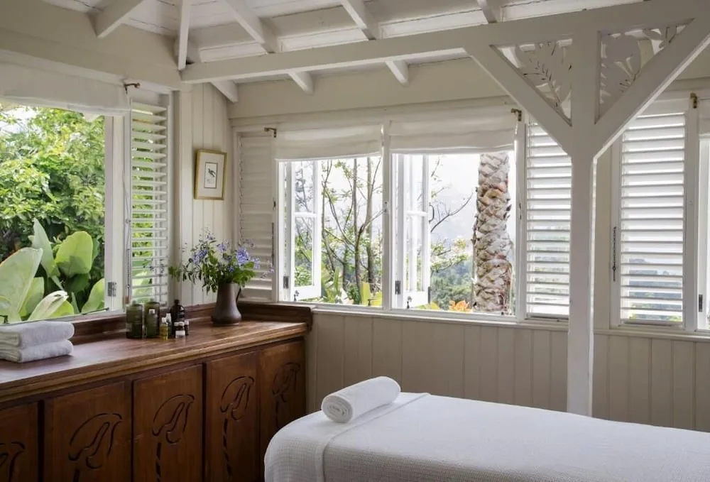 Spa treatment room with massage table and open shutters at Strawberry Hill.