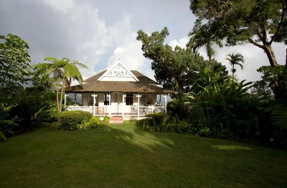 White cottage with veranda on a green lawn at Strawberry Hill.