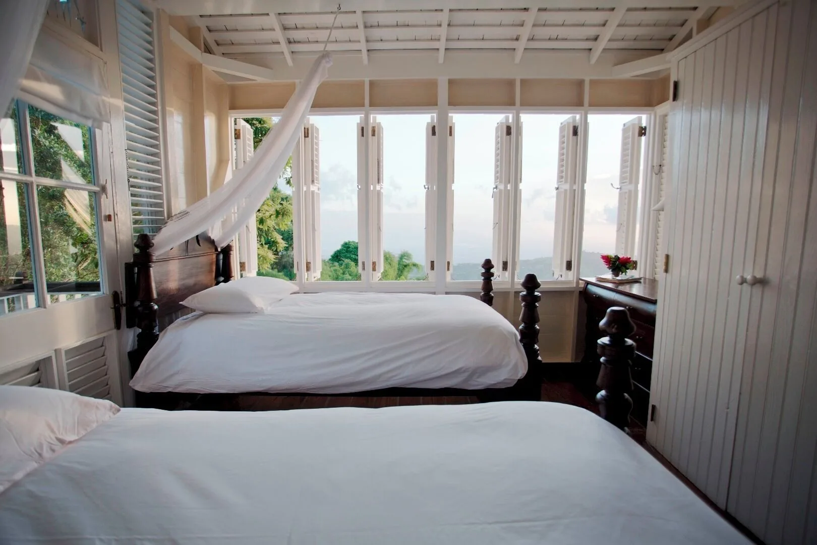 Two white beds in a Cottage 2 Bedrooms room at Strawberry Hill with wide windows and hillside views.
