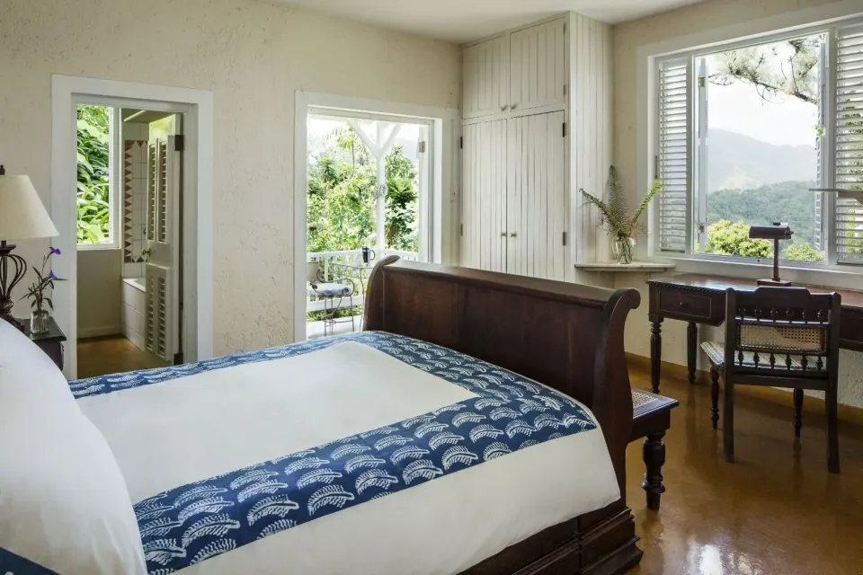 Cottage studio guest room with a sleigh bed, desk, and mountain-facing windows at Strawberry Hill.