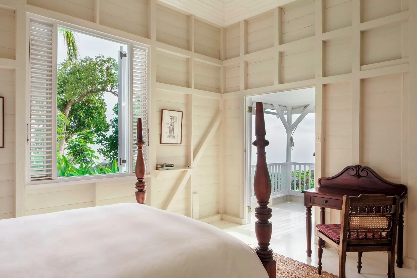 Studio Suite at Strawberry Hill with a four-poster bed, open shutters, desk, and veranda doorway.