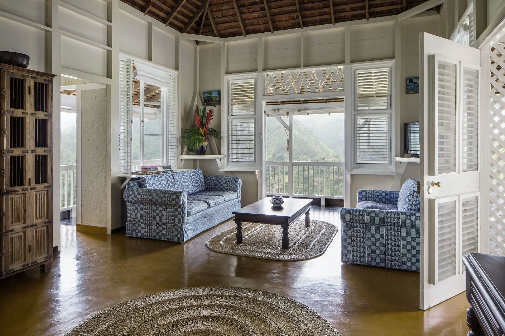 Villa 2 Bedrooms living room with blue seating and balcony view at Strawberry Hill.